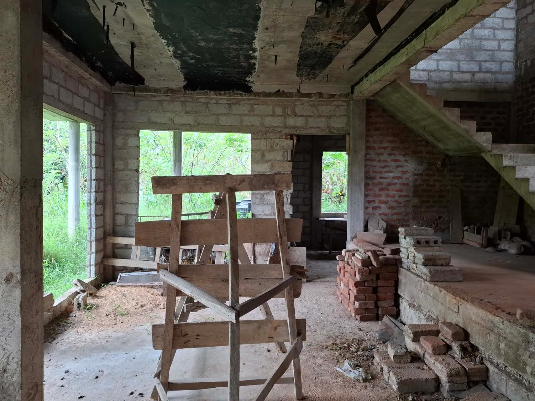 Second-floor living area showing the unfinished stair and masonry