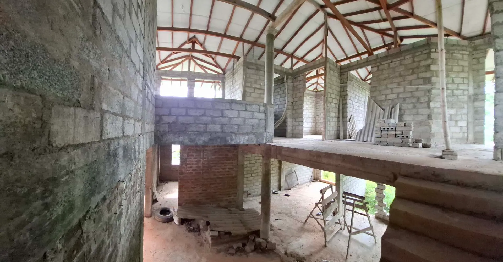 Wide view of the stairs arriving at the unfinished top floor